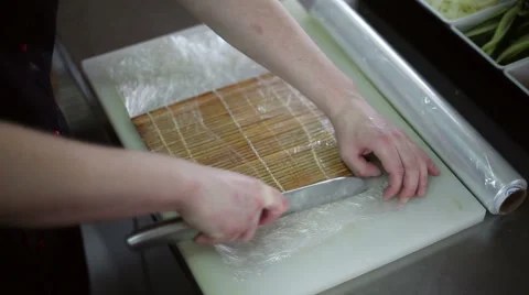 A sushi chef prepares the bamboo mat to tighten the roll Stock Footage 59698188
