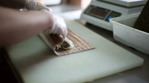 A sushi chef prepares rolls with a bamboo mat Stock Footage 59698293