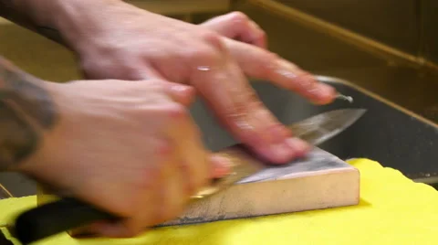 Sushi Chef Sharpening his Knife with a Pink Stone Stock Footage 52634843