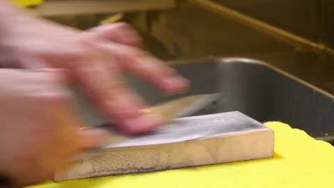 Sushi Chef Sharpening his Knife with a Pink Stone Stock Footage 80557124
