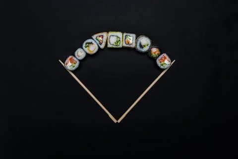 Sushi. Composition of assorted sushi rolls with chopsticks, isolated in black Stock-Fotos