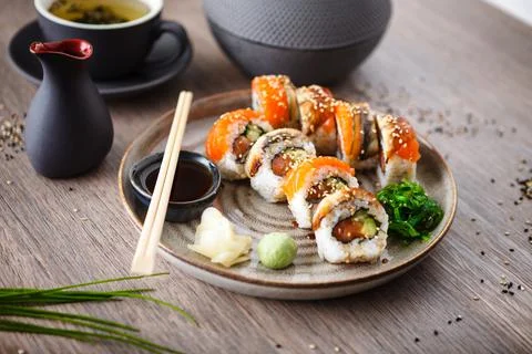 Sushi maki rolls with salmon, eel, avocado, cucumber on a plate with chopsticks Stock Photos