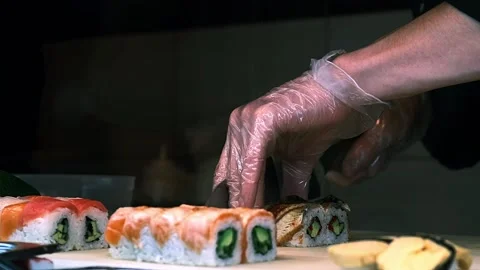 Sushi master cuts rolls with eel Stock Footage 229201098