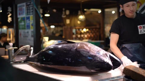 Sushi master is demonstrating in tuna cutting show at Kuroshio Market Stock Footage 99861464