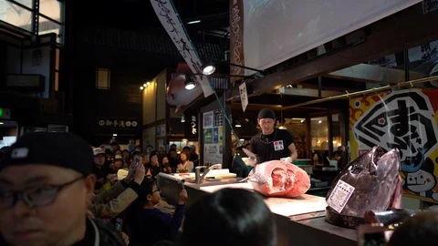 Sushi master is demonstrating in tuna cutting show at Kuroshio Market Stock Footage 99861524