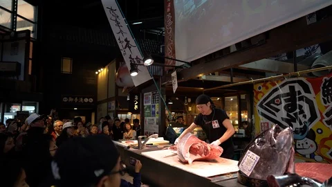 Sushi master is demonstrating in tuna cutting show at Kuroshio Market Stock Footage 99861548