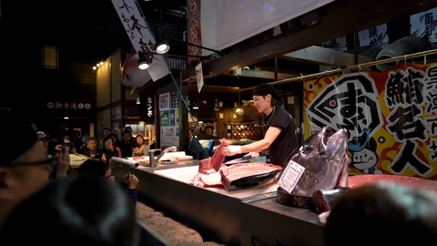 Sushi master is demonstrating in tuna cutting show at Kuroshio Market Stock Footage 99861569