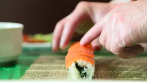Sushi master puts salmon on rolls Stock Footage 61384028