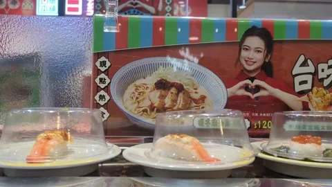 Sushi plates placed on a rotating conveyor belt inside restaurant Stock Footage 327770007