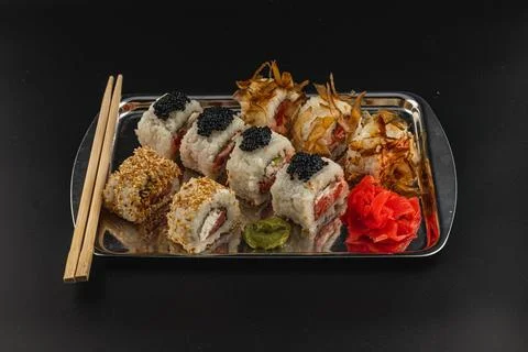 Sushi platter featuring various rolls and garnishes served on a tray Stock Photos