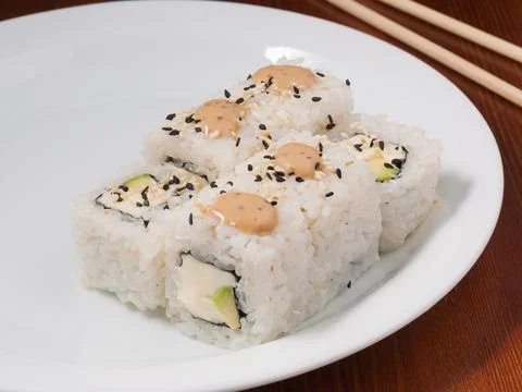 Sushi roll with avocado and cheese on a white plate Stock Photos