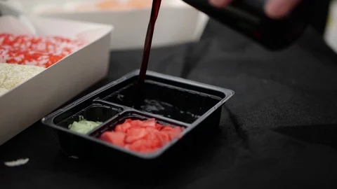 Sushi roll close-up in a box, slow mo wasabi and soy sauce, delicious food deliv Stock Footage 127541805