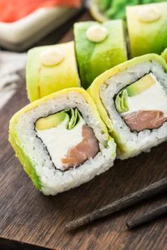 Sushi roll covered with avocado Stock Photos