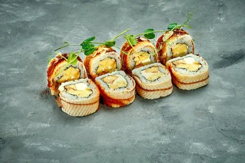 Sushi roll with eel and cream cheese, banana on gray background. Selective fo Stock Photos
