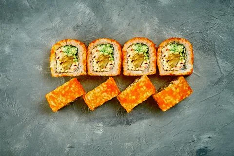 Sushi roll with eel and cucumber on gray background. Selective focus, noise a Stock Photos