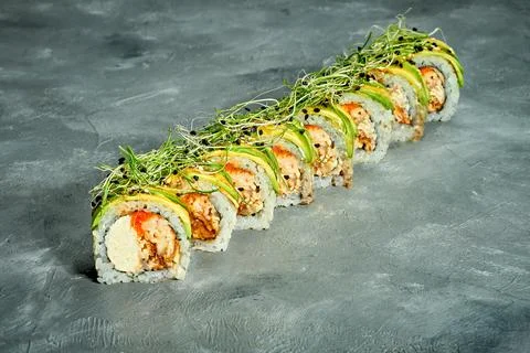 Sushi roll with eel, avocado and cream cheese on a gray background. Selective Stock Photos