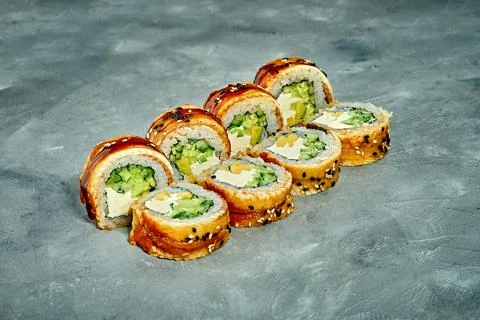 Sushi roll with eel, cucumber and cream cheese on a gray background. Selectiv Stock Photos