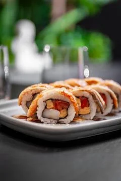 Sushi roll with eel, scallop, tomato and tamago on a plate Stock Photos