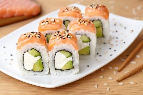 Sushi roll with feta cheese, avocado, cucumber, salmon and sesame seeds Stock Photos