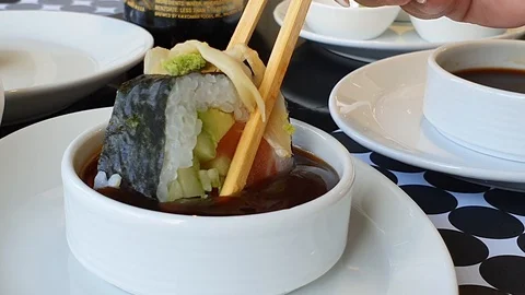 A sushi roll with salmon being held by wooden chopsticks Stock Footage 125913178