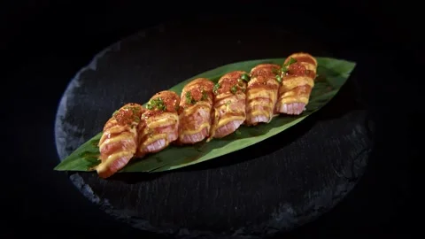 Sushi roll is spinning in a black container close-up. Stock Footage 239100928
