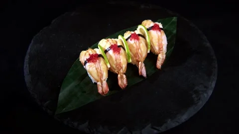 Sushi roll is spinning in a black container close-up. Stock Footage 239100943