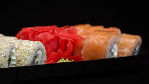 Sushi Roll is Spinning in a Black Container Close-up Video stock 263757347