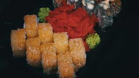 Sushi Roll is Spinning in a Black Container Close-up Stock Footage 263915095