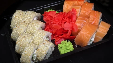 Sushi Roll is Spinning in a Black Container Close-up Stock Footage 264115444