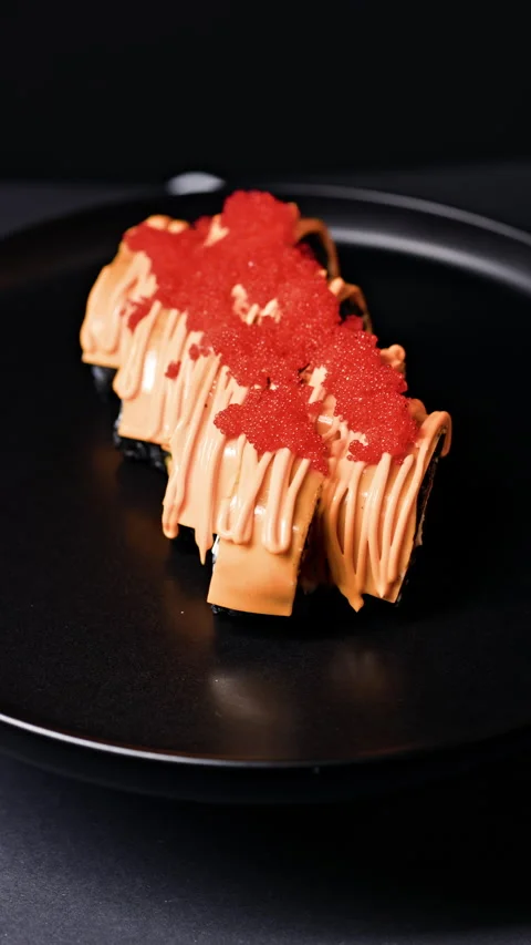 Sushi rolls are served on a black plate with colorful toppings and a dark 動画素材 341112906