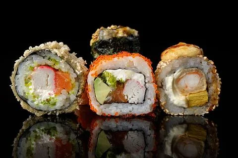 Sushi rolls of different types on a black background Stock Photos