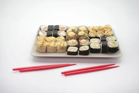 Sushi rolls on a light rectangular plate, isolated background Stock Photos