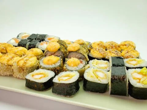 Sushi rolls on a light rectangular plate, isolated background Stock Photos