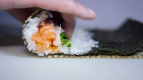 Sushi rolls making process with man's fingers Stock Footage 68312753