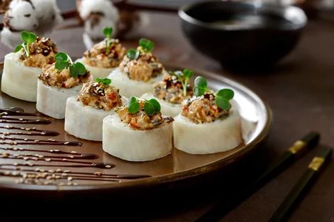 Sushi rolls in mamenori with eel, cream cheese, avocado, daikon, unagi sauce Stock Photos
