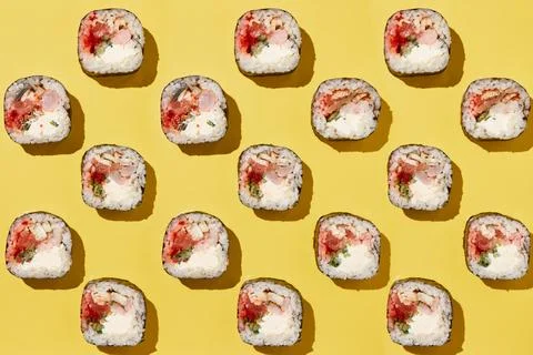 Sushi rolls pattern on yellow background. Stock Photos