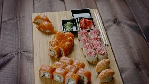 Sushi rolls with raw fish rotates on wooden board. Japanese traditional food Stock Footage 146966725