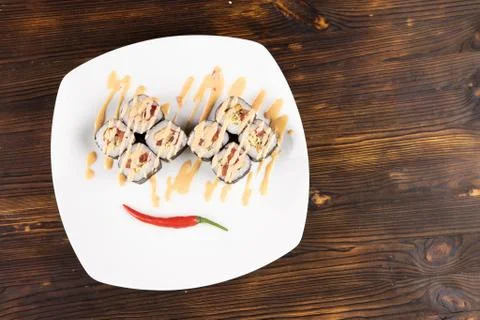 Sushi rolls with red pepper chilli on white plate top view Stock Photos