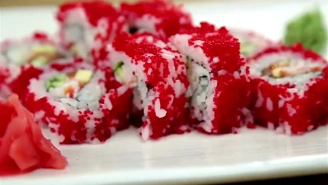 Sushi rolls with red roe rotate on white plate Video stock 333834435