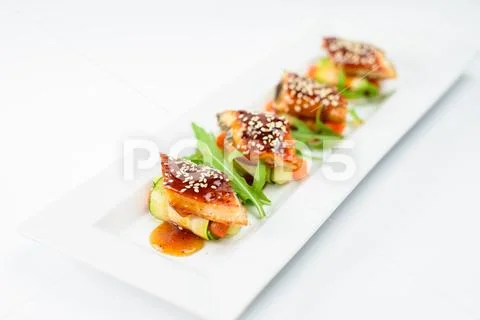 Sushi rolls with sesame seeds on a white plate, high cuisine Stock Photos