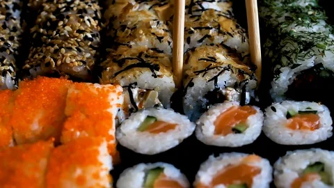 Sushi set on a black table. Chopsticks take sushi close-up. Stock Footage 121152385