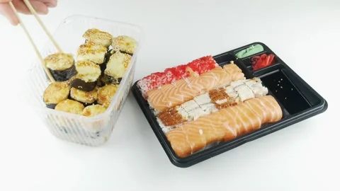 Sushi from the store in plastic packaging.Try a piece and dunked in soy sauce. Stock Footage 137285617