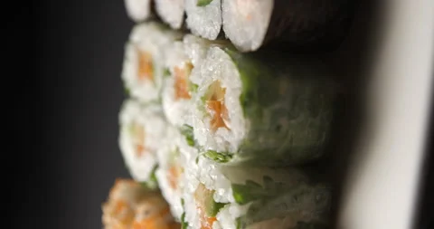 Sushis rotating close ups on black background 4K, vertical view Stock Footage 260137712