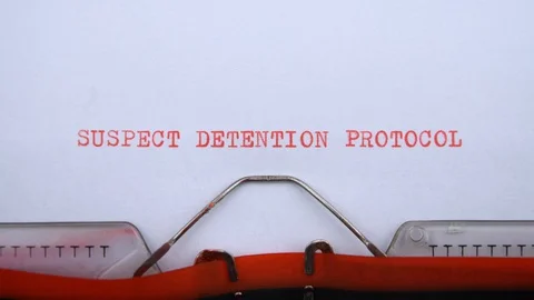Suspect detention protocol - phrase printed on an old typewriter in red letters Stock-Footage 128400497
