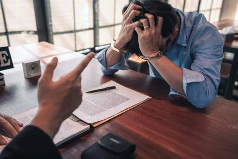 Suspect with handcuffs being interviewed in interrogation room by Police offi Stock Photos