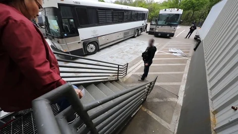 Suspect illegal migrant workers exiting workplace towards police officer Stock Footage 105798997