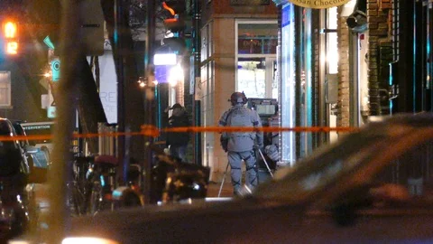 Suspect moving in the distance while cop pays close attention to him Stock Footage 100178604