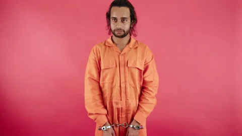 Suspect stands in custody glancing around carefully Stock Footage 297242261