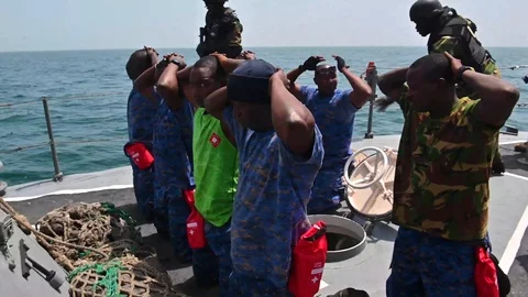 Suspect traffickers kneeling aboard boat during Exercise Obangame Express Vídeos de archivo 105646826