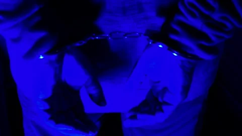 A suspect&amp;#039;s handcuffed hands under flashing police lights during arrest Stock Footage 318835299